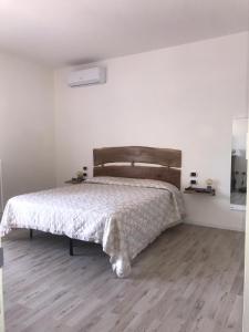 1 dormitorio con 1 cama y suelo de madera en Civico 7 en San Giacomo degli Schiavoni
