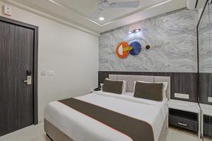 1 dormitorio con 1 cama grande y una pintura en la pared en Super Collection O Hotel Alpha One, en Ahmedabad