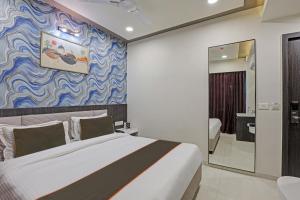 1 dormitorio con 1 cama y una pared azul y blanca en Super Collection O Hotel Alpha One en Ahmedabad