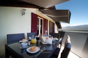 a black table with food on top of a balcony at Melaniesguesthouse 4 Zimmerwohnung in Caldaro +19 photos
