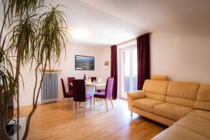 a living room with a couch and a table and chairs at Melaniesguesthouse 4 Zimmerwohnung in Caldaro