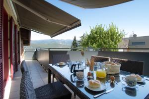 a table with food and drinks on a balcony at Melaniesguesthouse 4 Zimmerwohnung in Caldaro