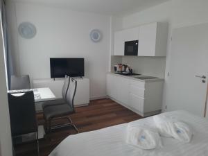 a room with a bed and a desk and a kitchen at Apartmány - Frymburk My Family in Frymburk