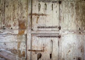 una antigua puerta de madera con un mango metálico en Ty Nain en Pwllheli