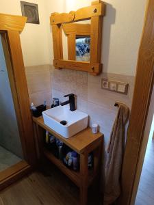 ein Badezimmer mit einem weißen Waschbecken und einem Spiegel in der Unterkunft Dolná chata u Bratríkov in Haligovce