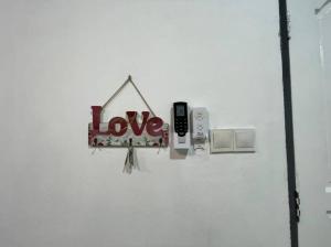 una señal con la palabra amor colgando de una pared en Double Storey terrace house in Sandakan Sabah, en Sandakan