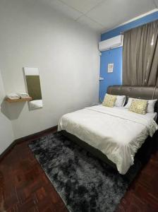 1 dormitorio con 1 cama grande y pared azul en Double Storey terrace house in Sandakan Sabah, en Sandakan