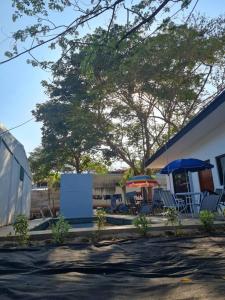 eine Gruppe von Stühlen und Sonnenschirmen neben einem Gebäude in der Unterkunft Casa Mar de Sueños Tamarindo in Tamarindo