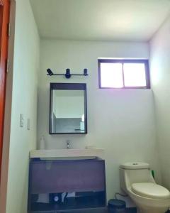 a bathroom with a sink and a mirror and a toilet at Casa Mar de Sueños Tamarindo in Tamarindo