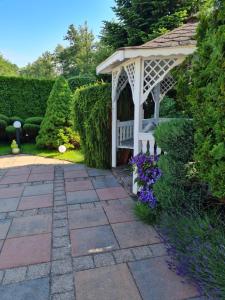 um gazebo com um banco num jardim em Willa Admirał em Trzęsacz