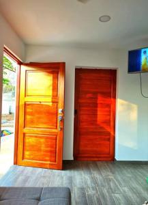 a room with a wooden door and a television at Casa Mar de Sueños Tamarindo in Tamarindo