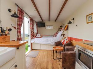 a living room with a couch and a bed at The Journeyman Luxury Shepherds Hut in Barnoldswick