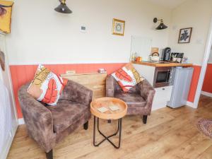 a living room with two chairs and a table at The Journeyman Luxury Shepherds Hut in Barnoldswick