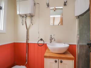 a bathroom with a white sink and a toilet at The Journeyman Luxury Shepherds Hut in Barnoldswick