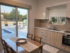 a kitchen with a dining table and a kitchen with a patio at Walnut Cozy House in Goudhi
