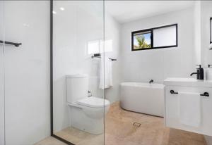 La salle de bains est pourvue de toilettes et d'une douche en verre. dans l'établissement The Place - Culburra Beach, à Culburra Beach