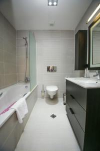 ein Badezimmer mit einer Badewanne, einem WC und einem Waschbecken in der Unterkunft Chagala Residence Atyrau in Atyrau