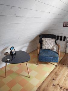 a living room with a chair and a table at Chambrecosy salle de bain privée in Quimper