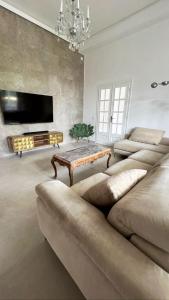 un soggiorno con un grande divano e una TV di Villa Giulietta Hotel a Castiglioncello