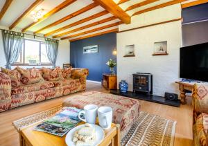 a living room with a couch and a fireplace at Penmaen Bach in Pwllheli