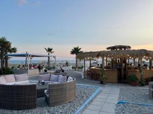 a patio with wicker couches and a bar and the ocean at Villa Lidia in Paola +19 photos