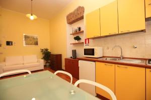 una cocina con armarios amarillos y una mesa con sillas en Roma family apartment en Roma