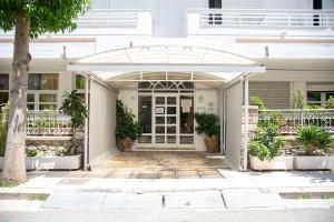 a white house with an arbor over the front door at STAVROS Studio Apartment in kos town in Kos Town