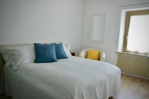 a bedroom with a bed with blue pillows and a window at B&B The Secret Garden in Buia