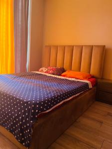 a bedroom with a bed with an orange wall at Natia rooms in Tbilisi City
