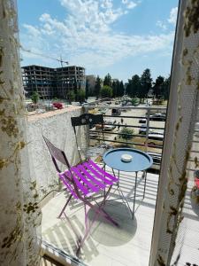a purple chair and a table on a balcony at Natia rooms in Tbilisi City