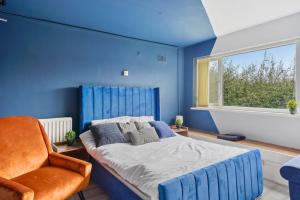 a blue bedroom with a bed and a chair at Large Studio Space Free Parking in Birmingham