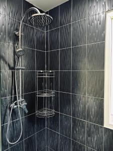 Baño de azulejos negros con ducha y 2 cestas en Peaceful Retreat Villa by Nai Thon beach en Phuket