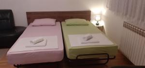 twee bedden in een kamer met handdoeken erop bij Fran in Novi Zagreb