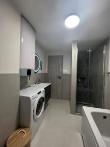 a bathroom with a washing machine and a sink at Vitas Apartments in Zaton