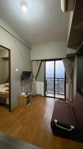 Apartemen Panoramic by Dio Property في باندونغ: غرفة معيشة مع سرير ونافذة كبيرة