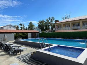 a swimming pool with chairs next to a building at LIONS APARTMENT in Ureki