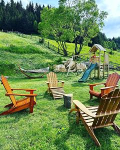 um grupo de cadeiras e um parque infantil num campo em Casa de sub Munte Fundata2 em Fundata