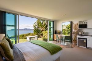 1 dormitorio con 1 cama grande y vistas al océano en Cable Bay Surf Studio, en Cable Bay