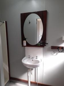 a bathroom with a sink and a mirror at KUR-Cow farm escape 35 minutes from Cairns in Kuranda