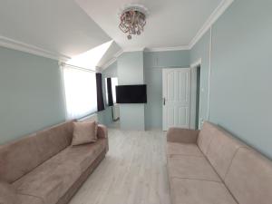 Una sala de estar con un sofá y un televisor. en Penthouse, en Trabzon