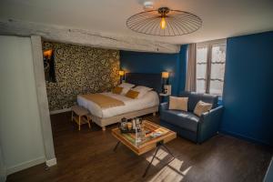 a bedroom with a bed and a couch and a table at Auberge de la Caillère - Teritoria in Candé-sur-Beuvron