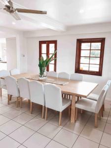 a dining room with a wooden table and white chairs at Homestead on the Range - Sleeps 12 in The Range