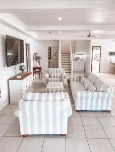 a living room with two white couches and a table at Homestead on the Range - Sleeps 12 in The Range