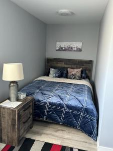 a bedroom with a bed with a blue comforter at Spotless 4 Bedrooms 4 Beds Sleep 8 in Winnipeg in Winnipeg