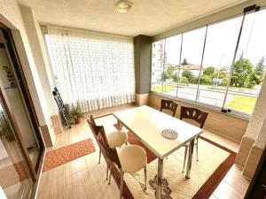 tavolo e sedie in una stanza con una grande finestra di luxury house with sea view a Trabzon