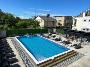 uma piscina com espreguiçadeiras ao lado em Hotel Lion em Ureki