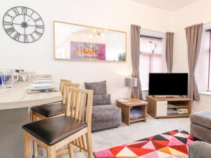 a living room with a table and a couch and a tv at Keepers Lodge in Carnforth