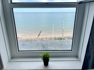 a window with a view of the beach seen through it at 7 Beach View Beaconsfield House in Bridlington