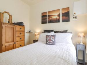 a bedroom with a white bed and a dresser at Keepers Lodge in Carnforth