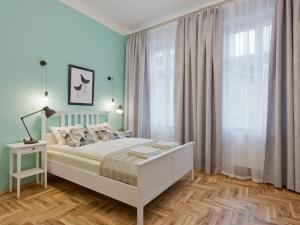 1 dormitorio con cama blanca y ventana grande en OK KRAK Apartments, en Cracovia
